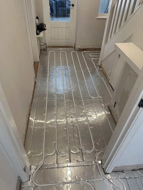 skilled installer fitting underfloor heating in Ferndown
